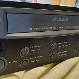 Černý digitální nahrávací zařízení s nápisem Alesis MASTERDISK ML-9600 HIGH-RESOLUTION MASTER DISK RECORDER. Na předním panelu jsou tlačítka POWER, O…