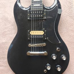 Černá elektrická kytara s dvěma humbuckery, z nichž jeden má zlatý kryt. Na těle jsou čtyři ovládací knofíky a přepínač tónu. Povrch laku vykazuje dr…