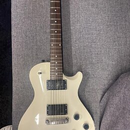Krémová elektrická kytara s tmavým hnedým hmatníkem. Na hlavě je bílý nápis "ALBERTO". Tělo má dva humbuckery, čtyři otočné knofíky a chromovaný most…