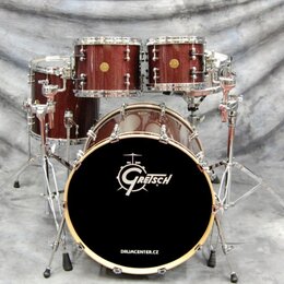 Bubnová sada v tmavě hnědé barvě s texturou dřeva a chromovaným kováním. Na přední bláně basového bubnu je bílé logo Gretsch a nápis DRUMCENTER.CZ. S…