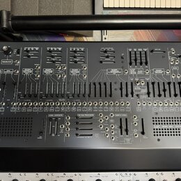 Černý analogový syntetizátor s nápisem ARP v levém dolním rohu a označením MODEL 2600 SYNTHESIZER v pravé dolní části. Přední panel obsahuje množství…