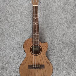 Akustický basový ukulele v dřevěném provedení s výřezem u krku. Na hlavě je nápis LANIKAI a uvnitř otvaru těla se nachází štítek s nápisem Lanikai HA…