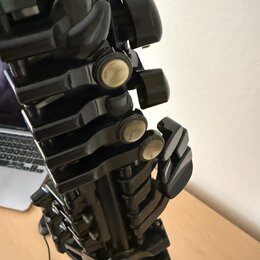 Detailní záběr na mechanismus černého dechového nástroje, pravděpodobně klarnetu. Jsou vidět kovové klapy s perleťovými vložkami a černé plastové neb…