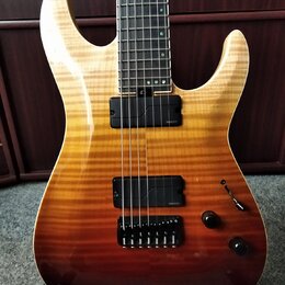 Elektrická kytara s tělem v žlutě-hnědém gradientu a plamenovitou strukturou dřeva. Nástroj má dva černé humbuckery, z nichž oba nesou nápis "Presici…