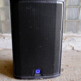 Černý reproduktor v hranatém provedení s kovovou mřížkou. Ve spodní části je umístěno kulaté modré logo s nápisem Q Turbosound. Povrch je v dobrém st…