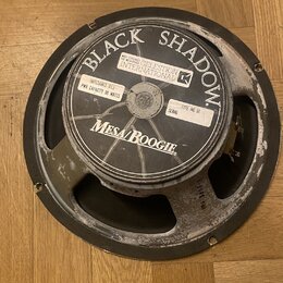 Kytarový reproduktor s černým rámem a membránou. Na středovém štítku je uveden nápis BLACK SHADOW, logo CELESTION INTERNATIONAL a značka Mesa/Boogie.…