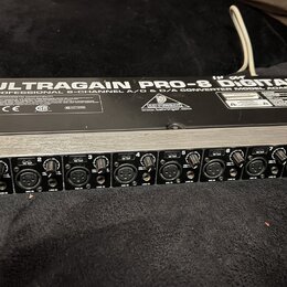 Stříbrný rackový přístroj s černým horním panelem. Na vrchu je bílý nápis ULTRAGAIN PRO-8 Digital a PROFESSIONAL 8-CHANNEL A/D & D/A CONVERTER MODEL…