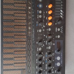 Černý MIDI kontrolér s klaviaturaí a ovládacím panelem. Na boku je svisle napsáno ARTURIA. Panel obsahuje oranžové posuvníky, několik černých otočnýc…