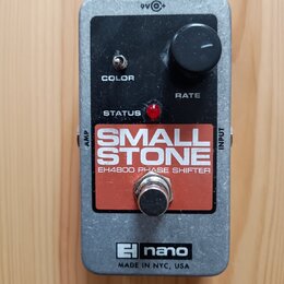 Kytarový efekt v kovovém šedém šasi s černým horním panelem. Na panelu je nápis SMALL STONE a pod ním EH4800 PHASE SHIFTER, ovládací knoflík RATE, př…