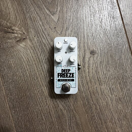 Bílý kytarový efekt pedál s nápisy ehx, DEEP FREEZE a NYC DSP. Na horní straně jsou čtyři bílé otočné oválné knoflíky s popisky MODE, DRY, EFFECT a S…