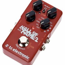 Červený kytarový efekt s nápisem HALL OF FAME 2 a logem tc electronic. Na horní straně jsou tři černé otočné oválkové knoflíky a jeden stoupací spína…