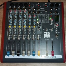 Míchací pult s červeným šasi a šedým ovládacím panelem. Na pravé straně je vidět logo ZED SIXTY 10FX a v dolní části nápis ALLEN&HEATH. Přístroj obsa…