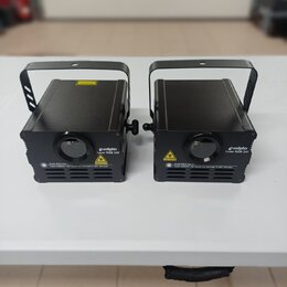 Dvě černé laserové světla v hranatých kovových skříních s úchytkymi rukojitmi. Na přední straně každého zařízení je nápis „vollights Laser RGB 1W“ a…