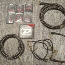 Sada příslušenství pro kytaru rozložená na šedém povrchu. Obsahuje šest balení stupenů s nápisem Ibanez GRIP WIZARD MADE IN JAPAN, krabičku strun Hea…