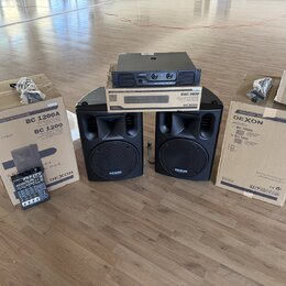 Sada zvukové techniky značky DEXON, která obsahuje dva černé reproduktory, zesilovač a mixovací pult. Na reproduktorech i krabicích je viditelný nápi…