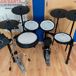 Elektronická bicí souprava s černými pady a činely. Na všech bílých plochách padů je vidět nápis Roland V-Drums. Součástí sestavy je ovládací modul,…