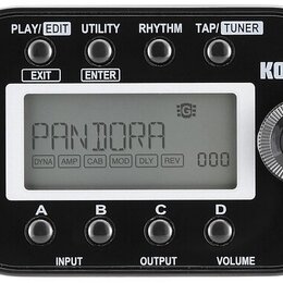 Černý kytarový procesor značky KORG s LCD displejem, na kterém je nápis PANDORA a hodnoty DYNA, AMP, CAB, MOD, DLY, REV a číslo 000. Zařízení má v ho…