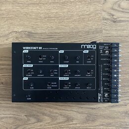 Černý analogový syntetizátor s nápisem WERKSTATT-01 ANALOG SYNTHESIZER a logem moog. Přístroj obsahuje různé ovládací knofíky, přepínače a sekce ozna…