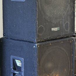 Dvě černé reproduktorové bedny s kovovou mřížkou v přední části, naskládané na sebe. Horní bedna má v pravém dolním rohu mřížky bílý nápis ibiza. Pov…