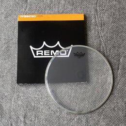 Průhledná bubenová blána s bílým logem REMO a nápisem "CLEAR CORNER" v horní části. Blána leží na černé obálce s bílým logem REMO a nápisem "DRUMHEAD…