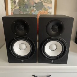Dva černé regálové reproduktory s bílými membránami basových jednotek. Na spodní hraně obou reproduktorů je umístěno kulaté logo značky Yamaha. Povrc…