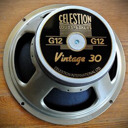 Reproduktor s kovovým rámem stříbrné barvy a černým krytem magnetu. Na krytu je zlatý nápis CELESTION LOUDSPEAKERS, G12 G12 a Vintage 30, v dolní čás…