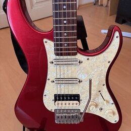 červeně lakovaná elektrická kytara s bílým perleťovým pickguardem. Kytara má tři snímače (dva jednoduché a jeden humbucker u kobylku) a třetí knofík.…
