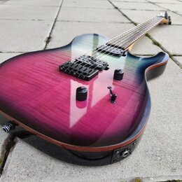 Elektrická kytara s tělem v purpurovo-černém gradientu a viditelnou strukturou dřeva. Nástroj má dva humbuckery, tři černé ovládací knofíky a jeden p…