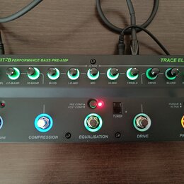 Šedý basový předzesilovač s nápisy TRANSIT B PERFORMANCE BASS PRE-AMP a TRACE ELLIOT. Horní řada obsahuje deset otočných ovladačů s podsvícením a pop…