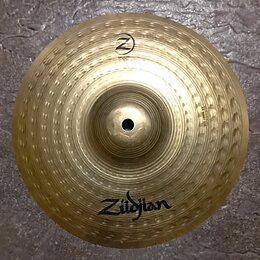 Zlatý kovový činel typu splash s hlouboko kladeným povrchem. Na spodní části je viditelné logo Zildjian a v horní části nápis SPLASH s logem Z. Na pr…