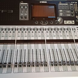 Digitální mixovací pult stříbrné a černé barvy. Na horním černém panelu jsou nápisy YAMAHA a TF3, displej a ovládací prvky. Spodní stříbrná část obsa…
