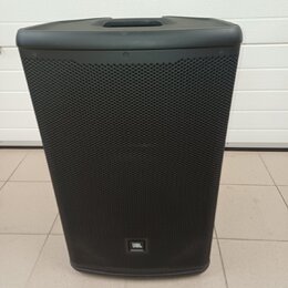 Černý reproduktor s kovovou mřížkou a integrovanou rukojetí v horní části. Ve spodní části je umístěno logo JBL. Povrch vypadá čistě a bez viditelnýc…