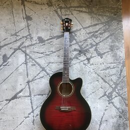 Akustická kytara s vyřezem (cutaway) v červenohnutém sunburst provedení. Na hlavě je viditelné logo Ibanez. Hриф má bílé polohovací značky a kytara j…