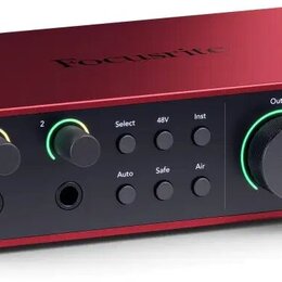 Červené audio rozhraní s černým předním panelem. Na horní straně je nápis Focusrite a vpravo dole na panelu Scarlett 2i2. Zařízení obsahuje dva vstup…