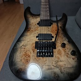 Elektrická kytara s tělem z přírodně vybarveného dřeva s výraznou strukturou a černým přechodem k okrajům. Nástroj má dva černé humbuckery, černý tre…