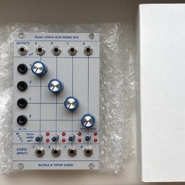 Modul syntezátoru v bílém provedení s nápisem QUAD LOPASS GATE MODEL 2921 a BUCHLA & TIPTOP AUDIO. Modul obsahuje čtyři modré otočné knoflíky, několi…