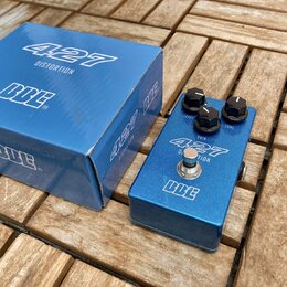 Modrý kytarový efekt v kovovém šasi s nápisy 427 DISTORTION a logo BCE. Na horní straně jsou tři černé otočné knoflíky s popisky LEVEL, GAIN a TONE.…