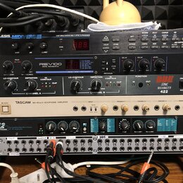 Sestupka rackových zařízení v černém a stříbrném provedení. Z horní části dolů jsou viditelné nápisy: ALESIS MIDIVERB III, YAMAHA REV100 DIGITAL REVE…