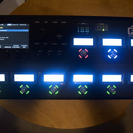 Černý procesor efektů Fractal Audio Systems FM9 Amp Modeller / FX Processor Mark II. Zařízení má LCD displej s textem „518: Derelict Tele“, několik p…
