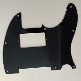 Černý plastový pickguard pro elektrickou kytaru. Povrch je hladký a lesklý, s několika vyvrtanými otvory pro šrouby. Na dílu nejsou žádné viditelné z…