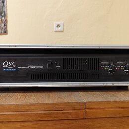 Černý výkonový zesilovač v hliníkovém racku. Na předním panelu je bílý nápis QSC AUDIO a model RMX 1850HD PROFESSIONAL POWER AMPLIFIER. Vpravo jsou o…