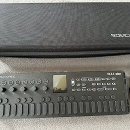 Černý syntezátor s nápisem SONICVARE a označením modelu ELZ1 play. Nástroj má řadu ovládacích tlačítek, několik otočných knoflíků a malý displej. Ved…