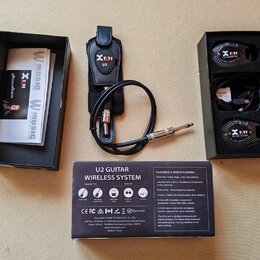 Sada bezdrátového systému pro kytaru U2 GUITAR WIRELESS SYSTEM v originálním černém balení. Obsahuje vysílač s nápisem Xvive U2, přijímač s nápisem X…