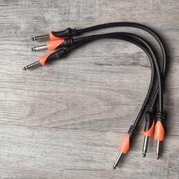 Tři černé audio kabely s oranžovými plastovými krytkami konektorů. Na každé oranžové krytce je bílý nápis bespece. Kabely jsou v dobrém stavu a leží…