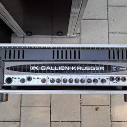 Černý basový zesilovač v hliníkovém transportním kufru. Na předním panelu je nápis GALLIEN-KRUEGER a logo GK, dále označení modelu 700RB. Zařízení ob…