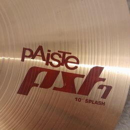 Detail kovového činely v zlatavé barvě s viditelným koncentrickým broušením. Na povrchu je červený nápis pAiste, pod kterým je stylizovaný červený ná…