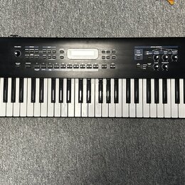 Černý digitální klavír s bílými a černými klávesami. Na levé straně je bílý nápis Roland JUNO-D. Horní panel obsahuje displej, několik tlačítek a oto…