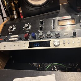 Na fotografii jsou dvě rackové jednotky v černém a stříbrném provedení. Horní černý přístroj nese nápisy WARM AUDIO a LA76 LIMITING AMPLIFIER s někol…