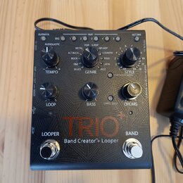 Černý efekt pedál s nápisem TRIO+ a Band Creator™+ Looper. Zařízení má tři ovládací knoflíky označené jako TEMPO, GENRE a STYLE, s dopisky LOOP, BASS…