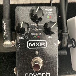 Černý kytarový efekt MXR reverb. Na horní straně jsou tři černé otočné ovnovátka s popisky DECAY, TONE a MIX. Uprostřed se nachází přepínač s nápisy…